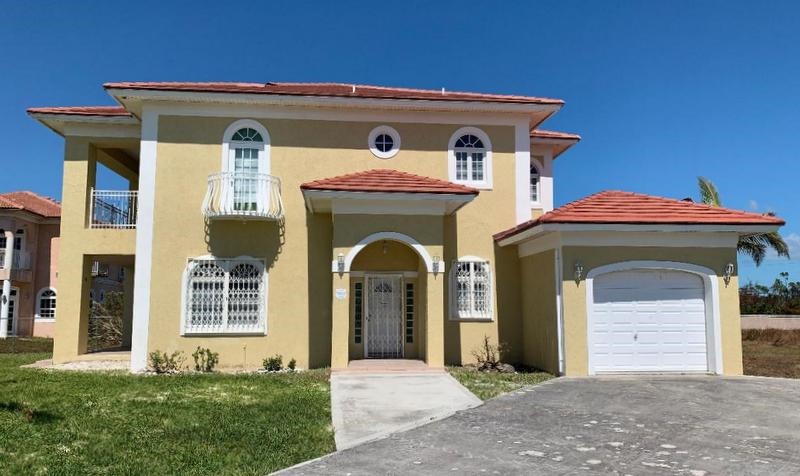 Yellow two-story house with red roof.